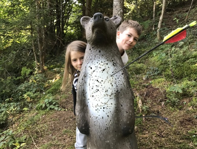 Kinder haben Spaß beim Bogenschießen auf die 3D-Ziele im Flachauer Waldparcours